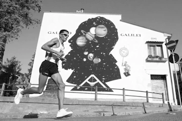 Daniele Meucci pass accanto al murales di Galileo Galilei