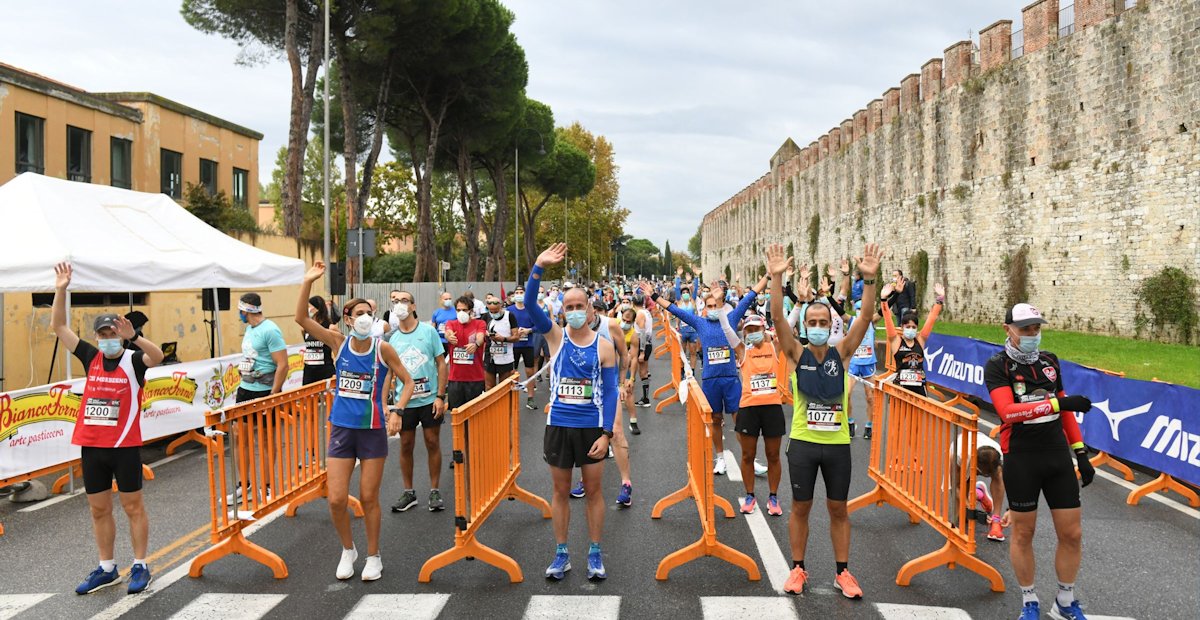 Atleti alla partenza della Pisa Half Marathon distanziati e con mascherina